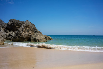 beach with rock cliff sand and ocean waves