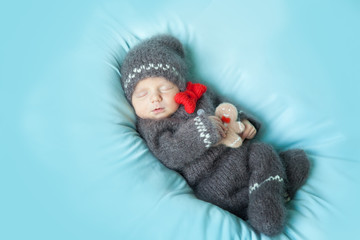 Sleeping newborn baby in a crocheted gingerbread man costume