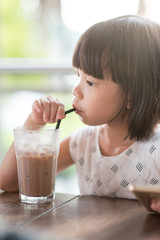 Little girl drinking at cafe
