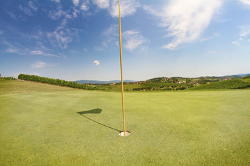 Obraz premium A golf hole at a golf course. The nature behind is beautiful.