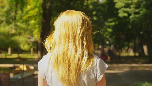 Girl in white shorts, riding a Segway on a clear sunny day. summer park and sun glare. 4k, slow-motion shooting, stadikam shot