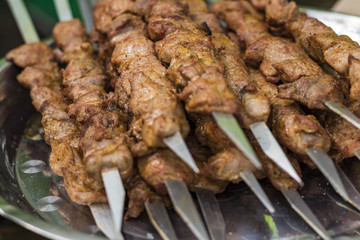 Fried shish kebab on skewers in smoke. Hot grill food