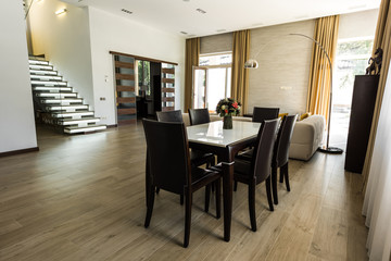 interior view of modern dining room with table, chairs and stairs