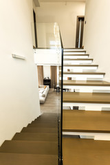interior view of modern stairs with glass railings to living room