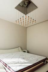 interior of stylish bedroom with bed and light bulbs on ceiling