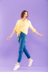 Fototapeta na wymiar Excited woman posing isolated over purple wall background.