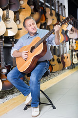 Man guitarist is playing on wooden acoustic guitar