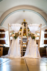 the chairs for wedding in the church, decorated with hearts