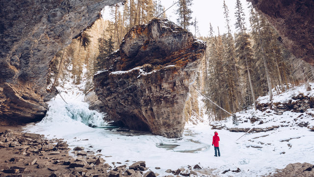 Person in snowy woods with big rocks