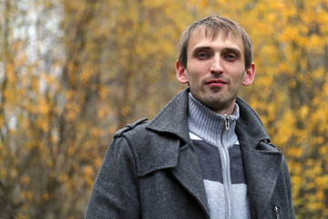 Autumn portrait of a young man on the street.