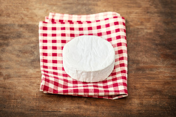 White soft Cheese Brie on wooden background, top view. Creamy cheese with copy space.