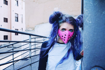 Chica joven con estilo urbano asiático y una máscara punk rosa con pinchos