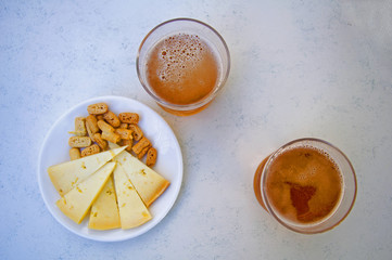 Two glasses of beer and snacks, center, atop