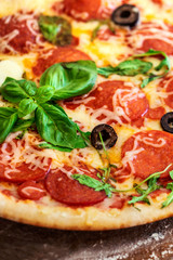 Hot pizza slice with Pepperoni, tomatoes, melting cheese on a rustic wooden board.