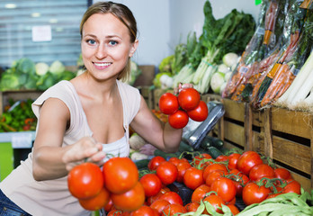 Portrait of  woman buying organic tomatoes in shop