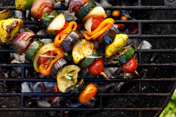 Vegan skewers of various vegetables on the grill plate, top view