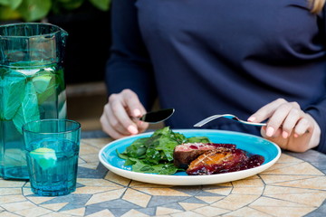 Duck breast with spinach leaves and berry sauce.