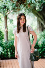 Portrait of a young, attractive and elegant Japanese Asian tourist posing in a park during the day....