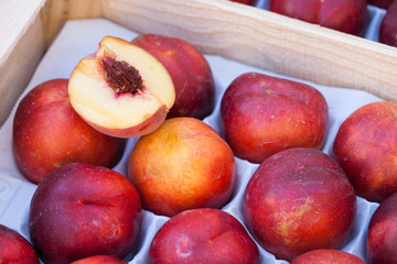 Une cagette de pêches sur l'étalage d'un marché