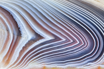 Amazing Banded Agate Crystal cross section as a background. Natural light translucent agate crystal surface, Gray abstract expressive structure slice mineral stone macro closeup