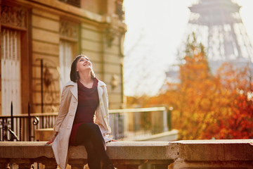 Young woman in Paris near the Eiffel tower on a fall day