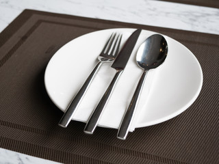 cutlery set fork knife and spoon on white plate.