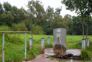 memorial inscription on the equipped water source in Russian-"dedicated to the mother"