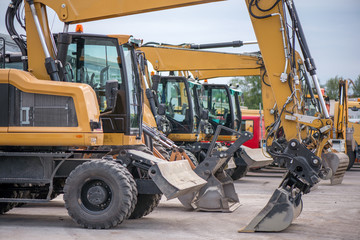 Multiple cars, excavators, trucks, loaders, concrete mixers and construction machinery in large...