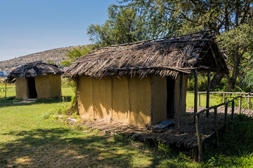 Fototapeta na wymiar Huts at the reconstructed site of a prehistoric settlement at the Kastoria Lake in Dispilio, Greece 
