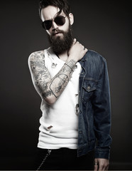 fashionable handsome man with tattoo and sunglasses