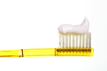 Close up of a toothbrush with toothpaste isolated on a white background with space for copy