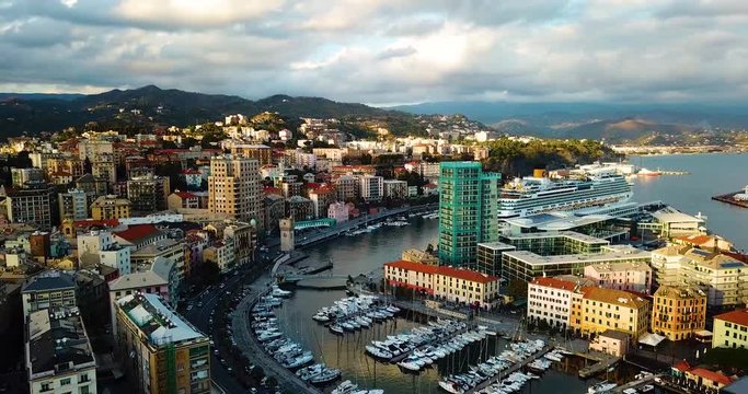 Cruise of Costa docked in a pier in italy in Savona with a nice sunset and beautiful view of a city by drone