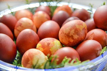 Easter eggs decorated with natural fresh leaves and boiled in onions peels, laying in wicker basket full of grass and thuja branches. dyeing eggs in the morning and celebrating Easter with family