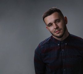 Young man studio shot portrait. Handsome in checkered shirt. Copy space dark grey background