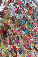 Lots of love locks, locked onto a bridge, colourful background