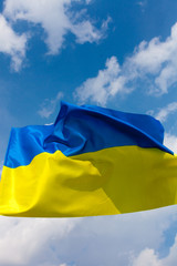 Flag of Ukraine against the blue sky. Vertical shot.