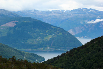 Fototapeta na wymiar View of Husedalen valley with cascade of four waterfalls and Kinsarvik fjord, Norway
