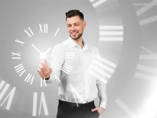 Young businessman using virtual screen on gray background