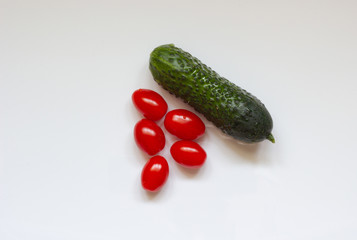 One cucumber and several tomatoes on a white background