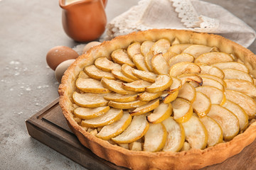 Wooden board with tasty homemade apple pie on table