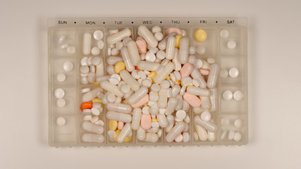 TOP VIEW: Very many pills lie in a pill dispenser