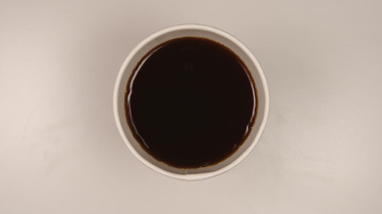 TOP VIEW: Hot dark coffee in a paper cup