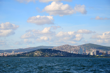 Fototapeta premium View to Istanbul from Prince's Islands (Büyükada). Sea cityscape with modern skyscrapers of Istanbul. Beautiful blue sky with white clouds