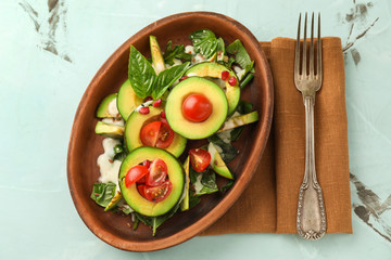 Plate with tasty avocado salad on table