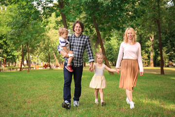 Obraz premium Happy family walking in green park