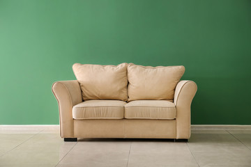 Comfortable sofa near color wall