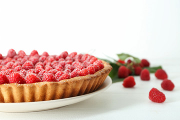 Tasty pie with fresh raspberries on white wooden background