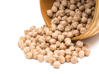 Overturned wooden bowl with chickpeas pouring out isolated on white background