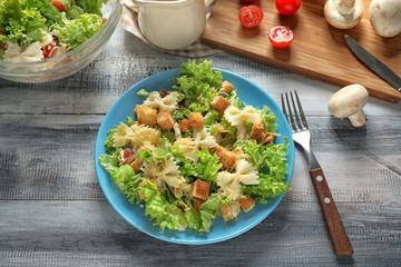 Tasty Caesar salad with pasta on plate