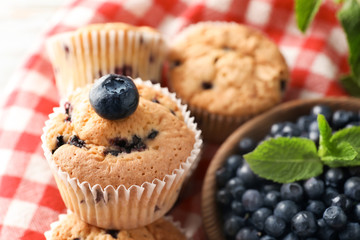Tasty blueberry muffins with fresh berries on table, closeup